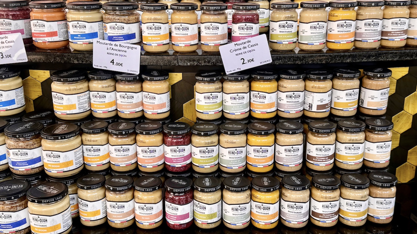 Eine beeindruckende Auswahl an Senfgläsern der Marke "Reine de Dijon" in einem Geschäft in Dijon, Frankreich, zeigt die Vielfalt der französischen Senfproduktion.