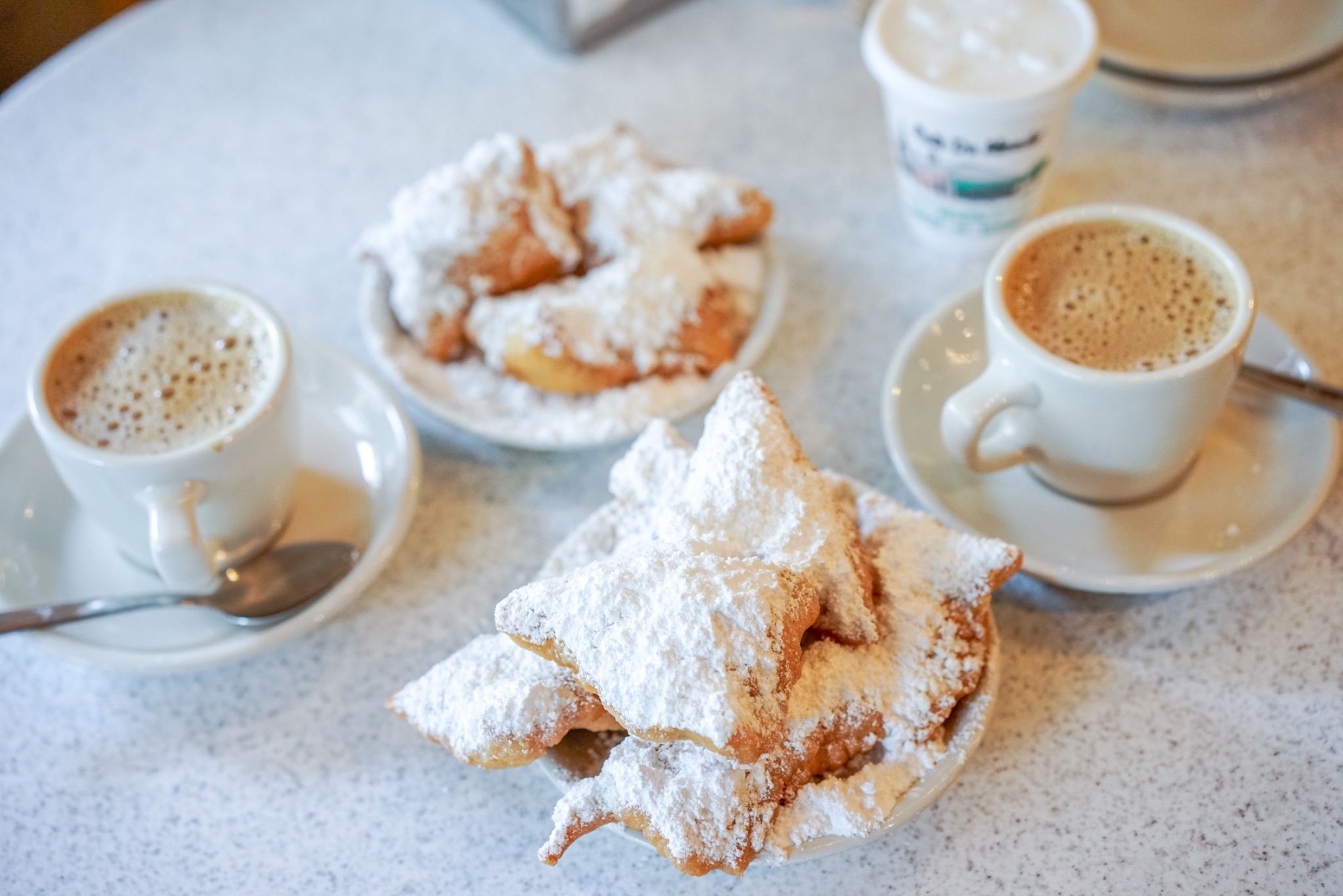 Beignets mit Puderzucker und Kaffee auf einem Tisch