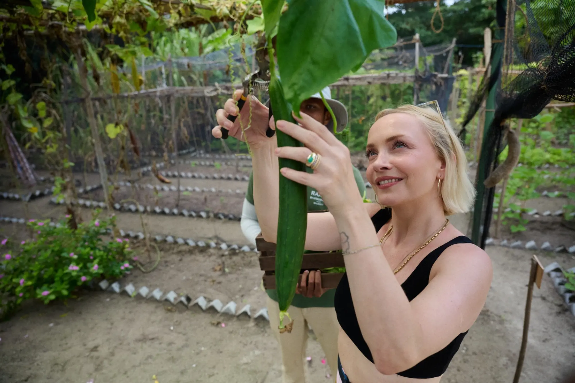Janin Ullmann betrachtet eine tropische Pflanze auf Seb’s Farm im RAAYA Resort.