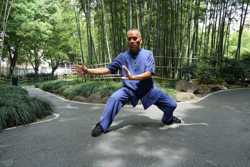 Ein Taijiquan-Großmeister führt eine Tai-Chi-Übung in einem Bambuswald in Shanghai aus.