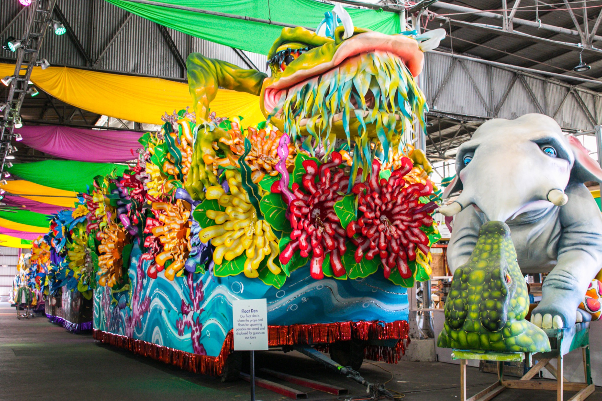 Bunt geschmückter Karnevalswagen in der Werkhalle von Mardi Gras World