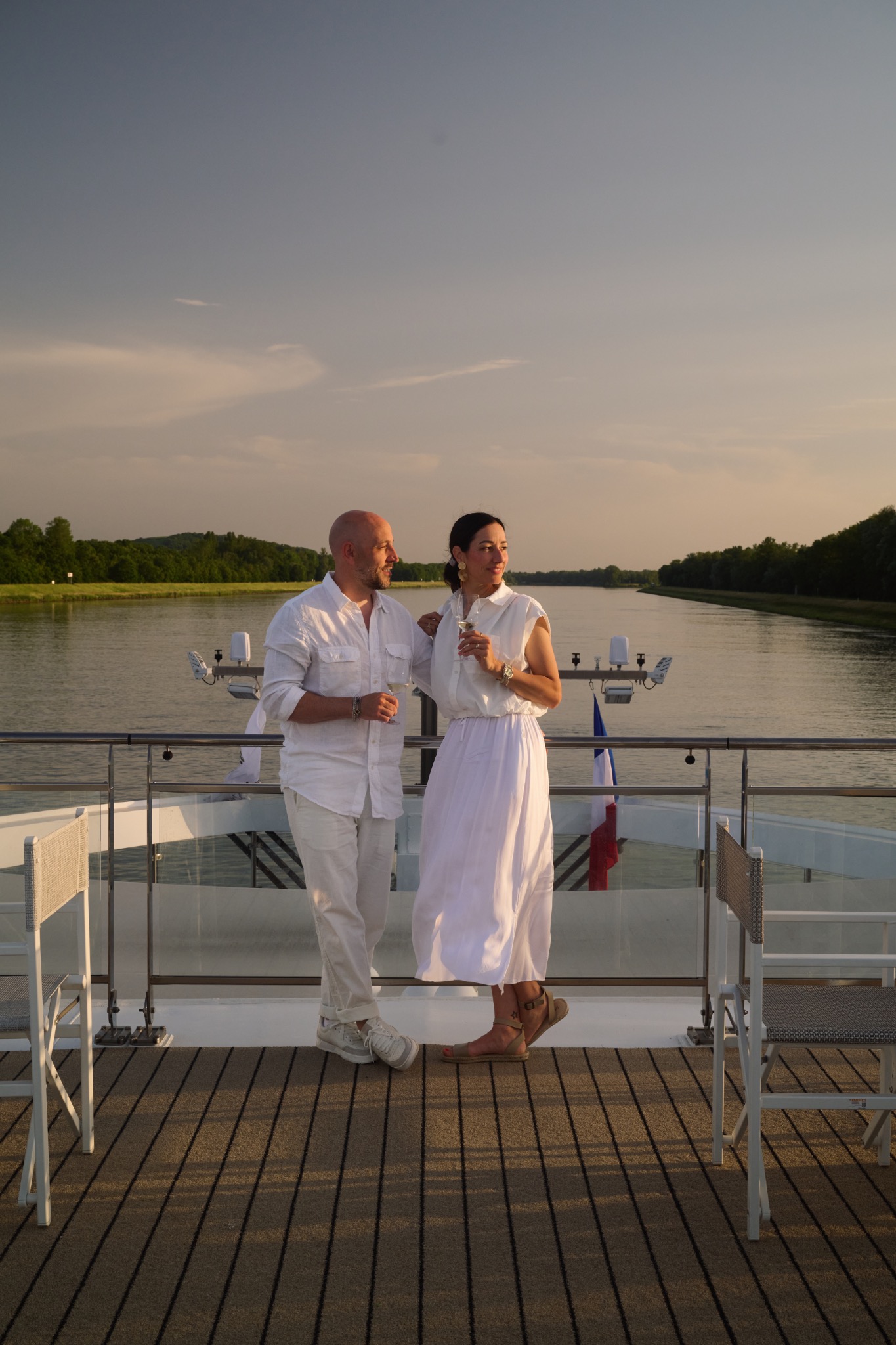 Zwei Reisende mit Getränken auf dem Deck eines Flussschiffs