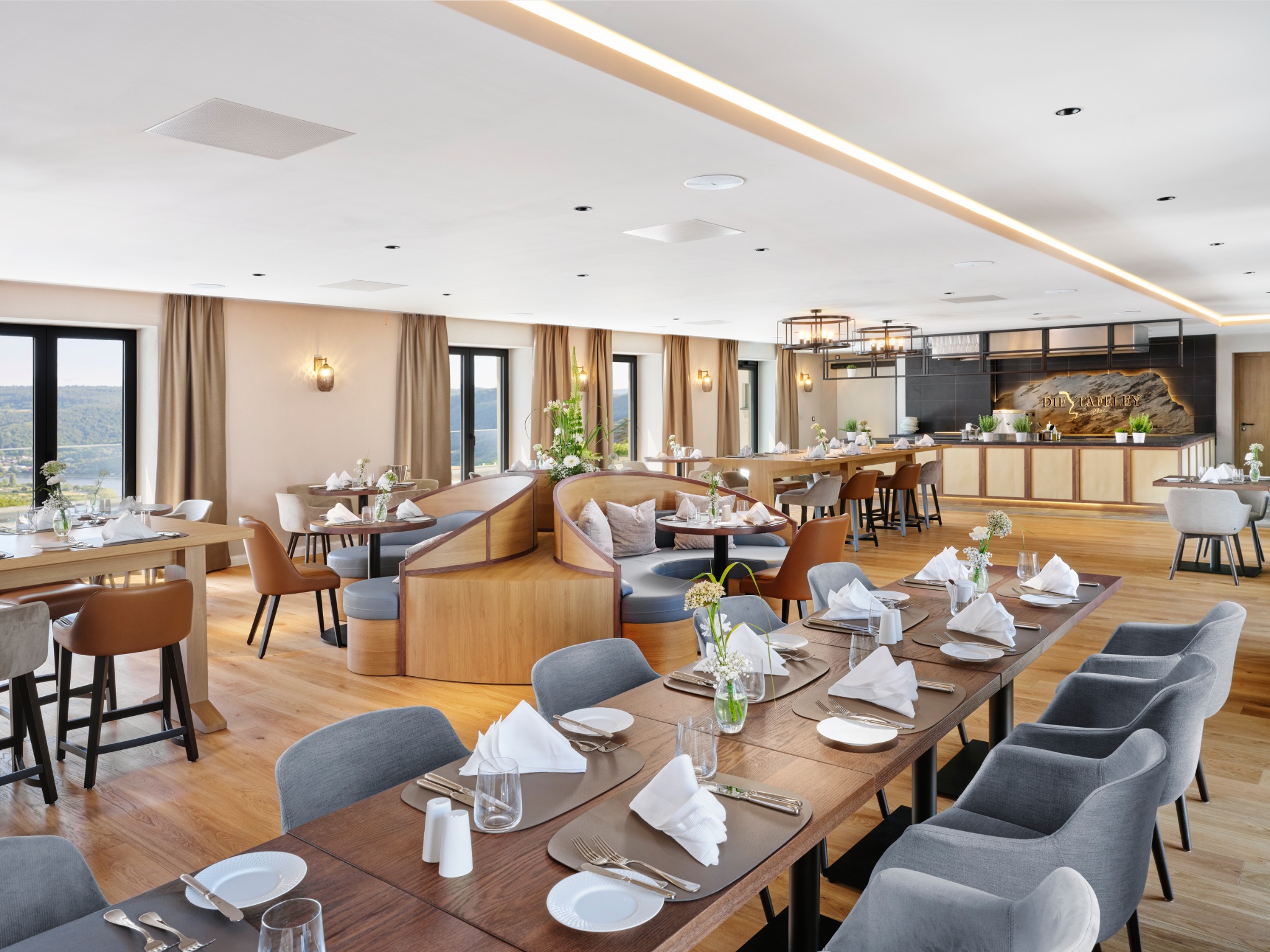 Eingedeckte Tische und offene Küche im Restaurant Die Tafeley