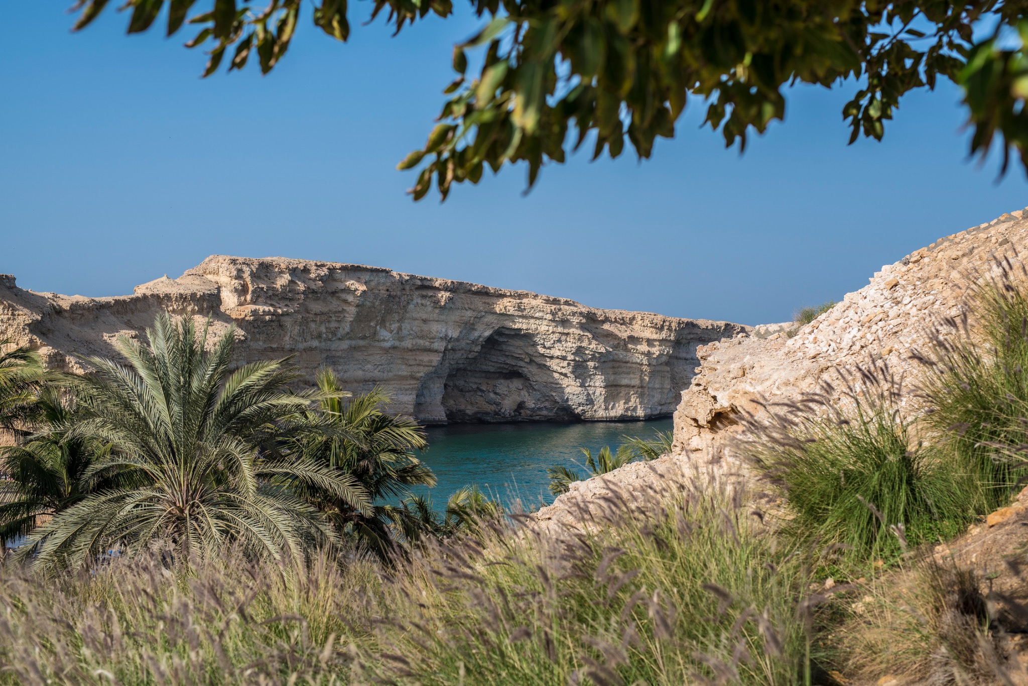 Felsige Küste und türkisblaues Wasser an der Bucht bei Al Husn in Oman