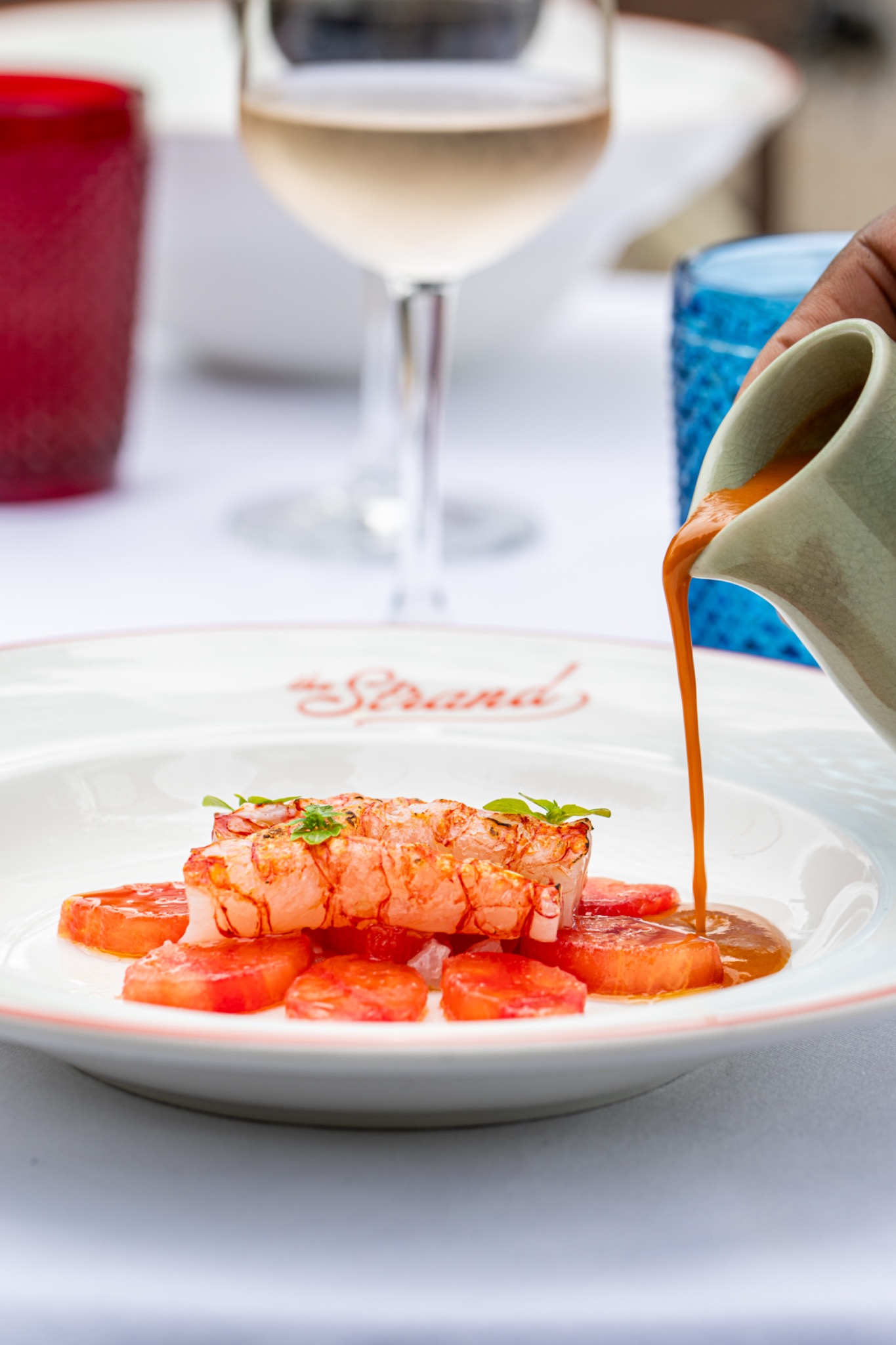 Ein Gericht mit Meeresfrüchten wird im The Strand mit Sauce angerichtet