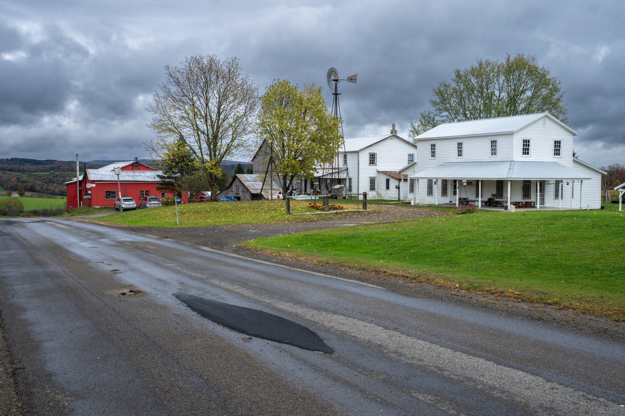 Weiße und rote Hofgebäude an einer ländlichen Straße entlang des Amish Trails.