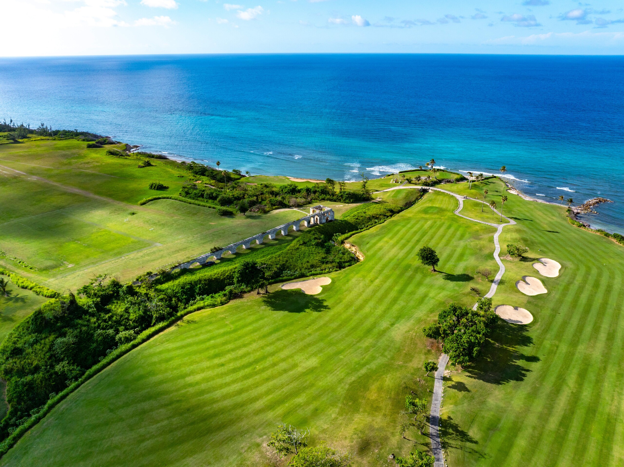 Golfplatz Cinnamon Hill auf Jamaika mit Fairways, historischen Mauerbögen und Blick aufs Meer