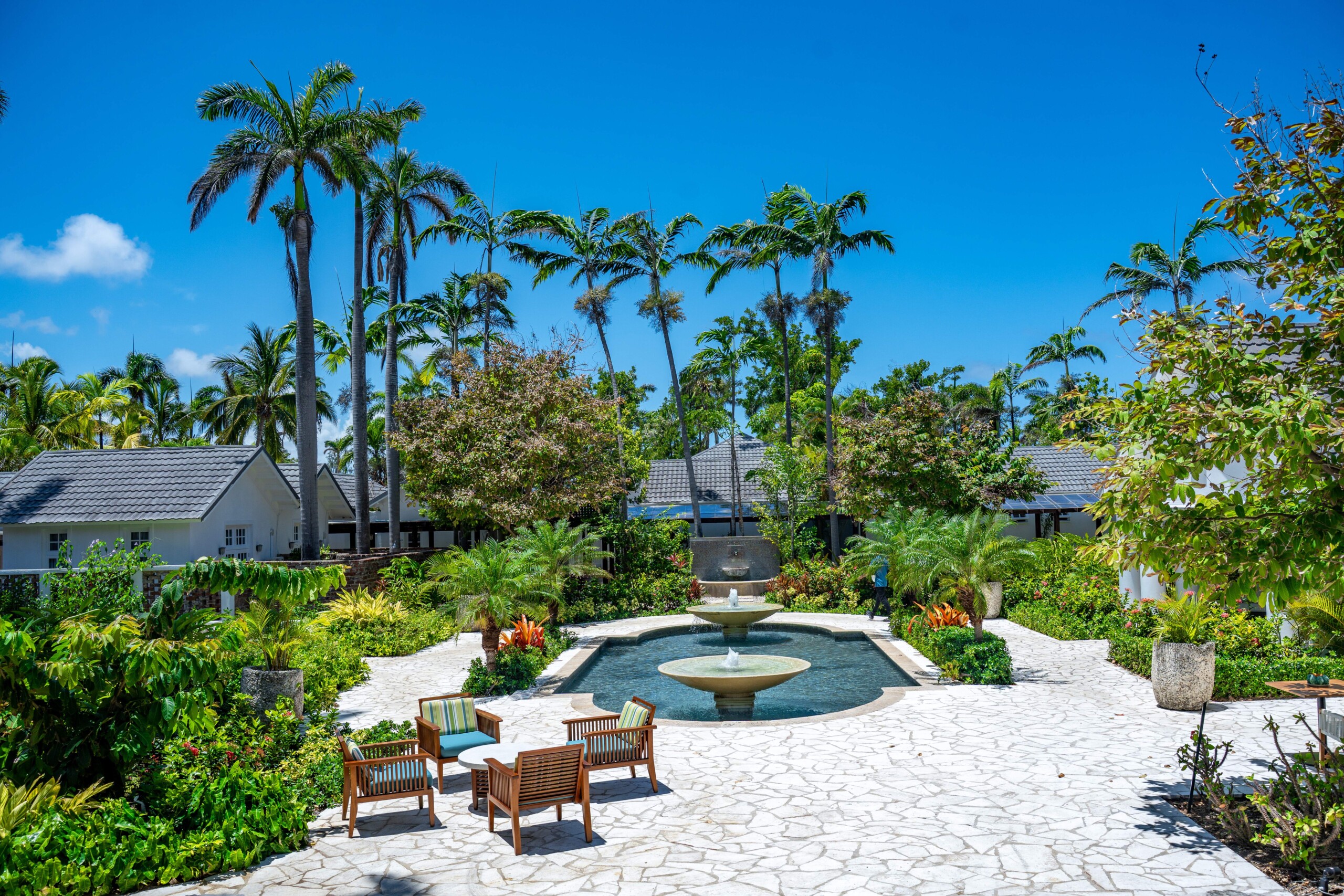 Gartenanlage des Half Moon Resorts mit Palmen, Brunnen und Sitzgelegenheiten