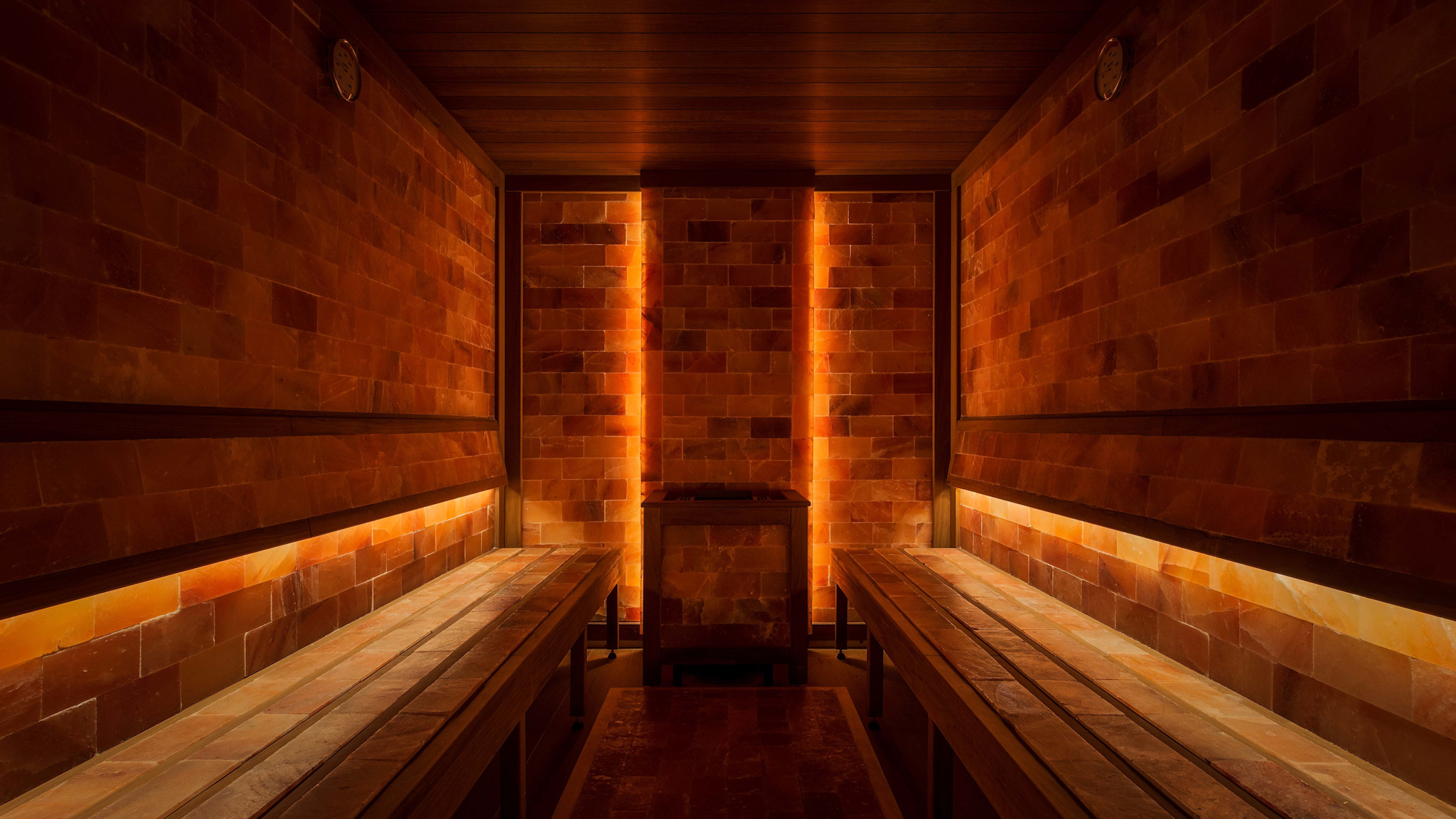 Beleuchteter Salzraum mit Holzbänken im eforea Spa des Hilton Costabella.