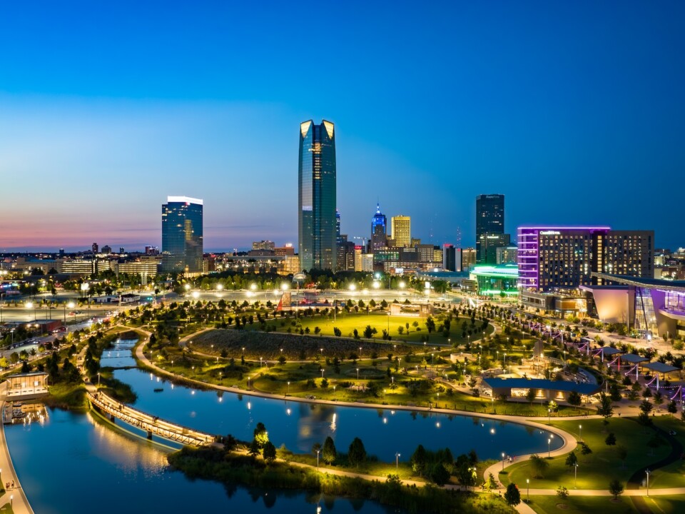Beleuchtete Skyline von Oklahoma City mit Park und Wasserfläche im Vordergrund