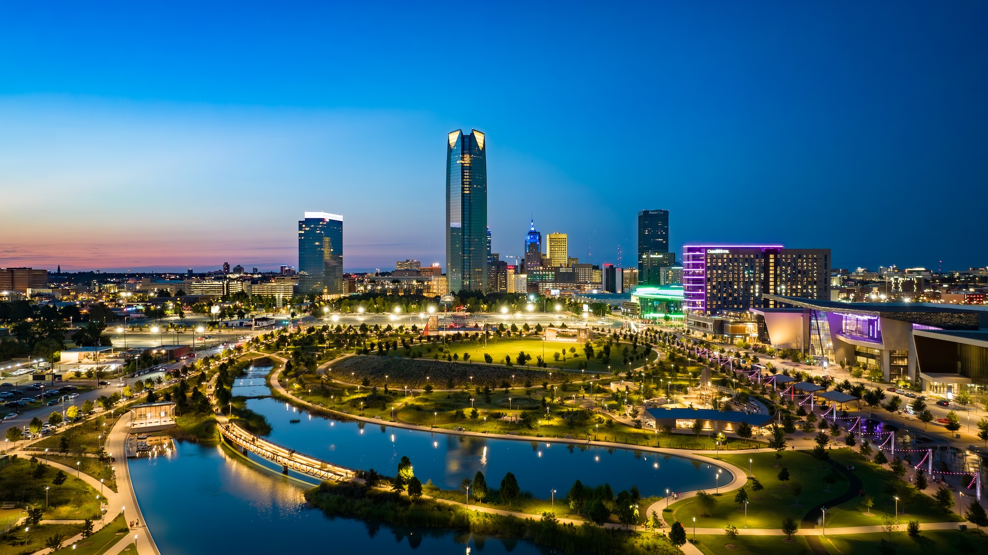 Beleuchtete Skyline von Oklahoma City mit Park und Wasserfläche im Vordergrund