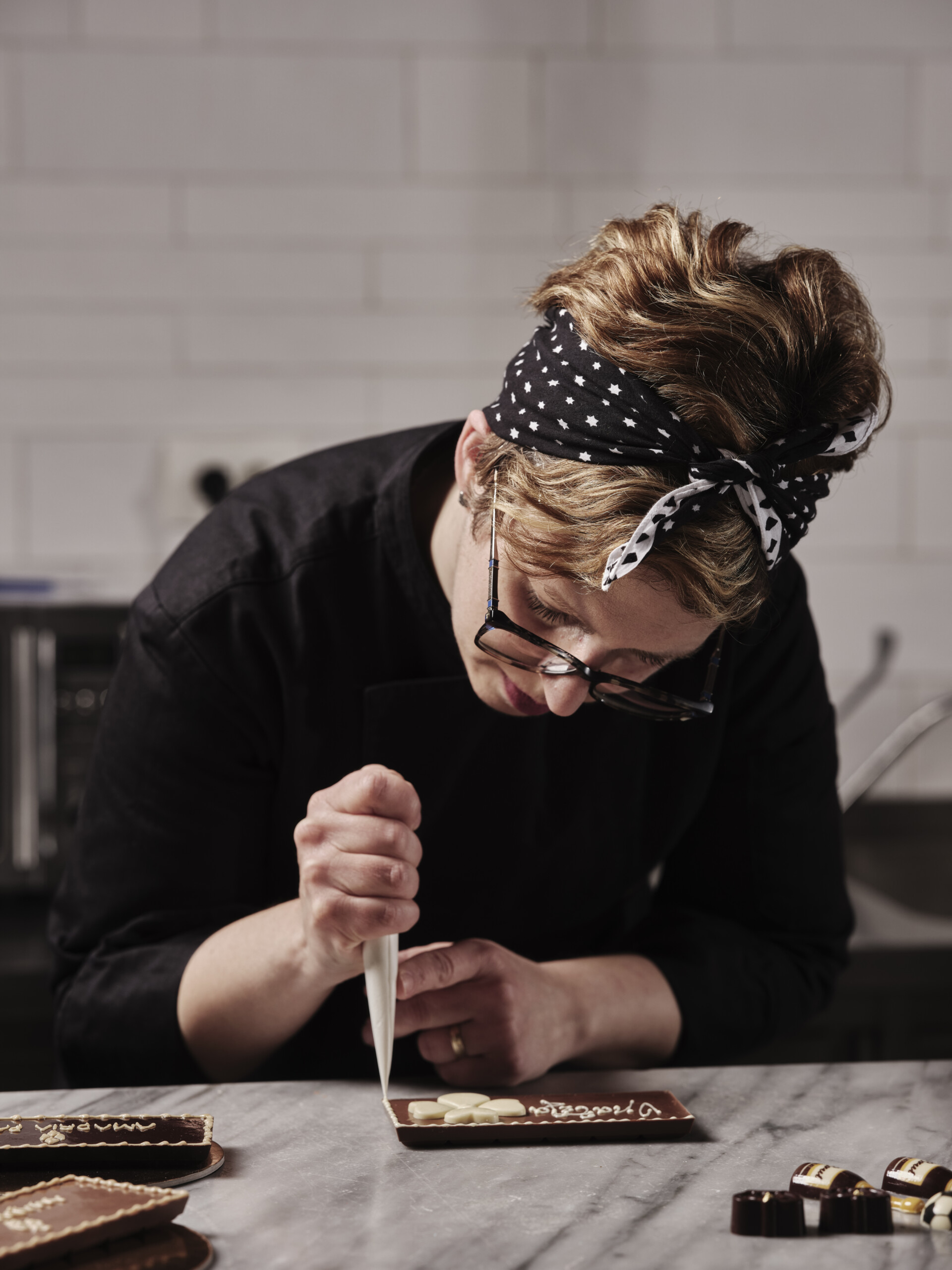 Chocolatier verziert in der Milenij Choco World eine Schokoladenkreation mit einem Spritzbeutel