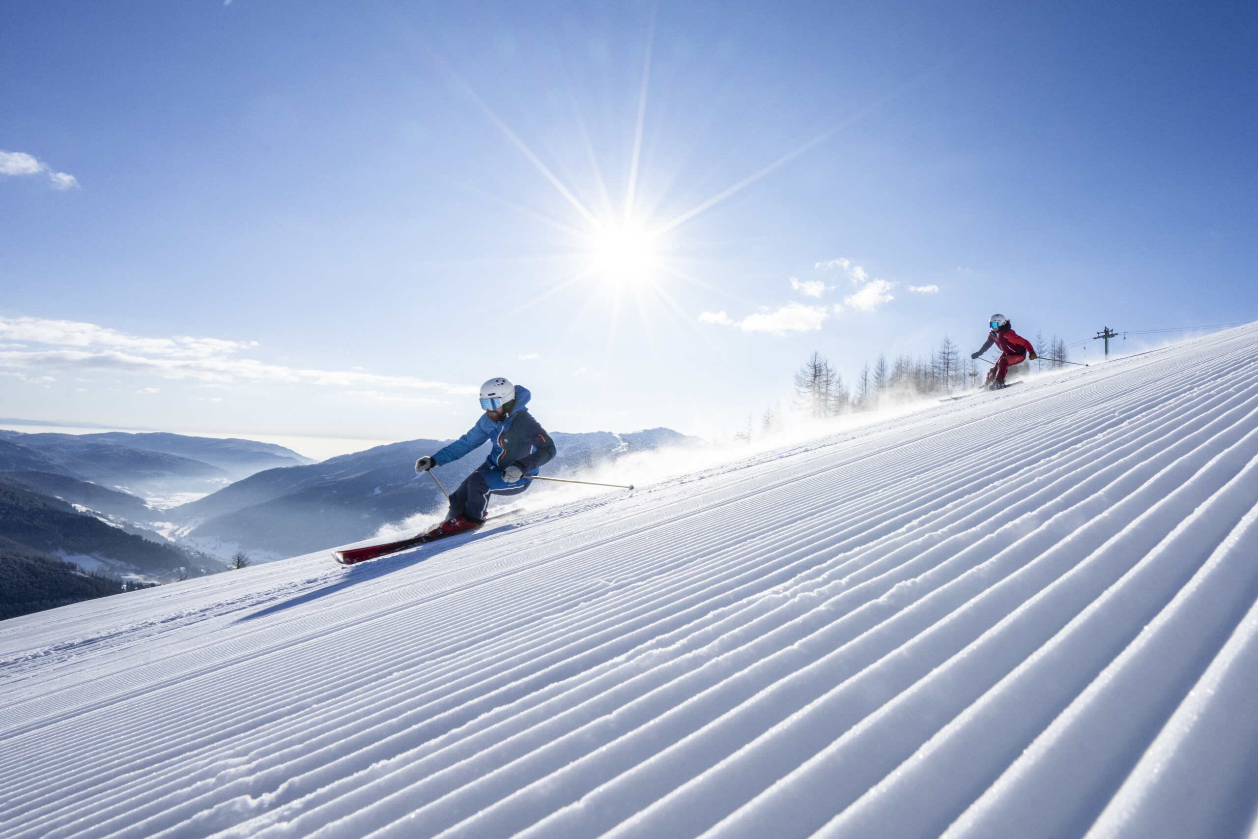 Skifahrer auf einer präparierten Piste in Bad Kleinkirchheim vor verschneiten Bergen.